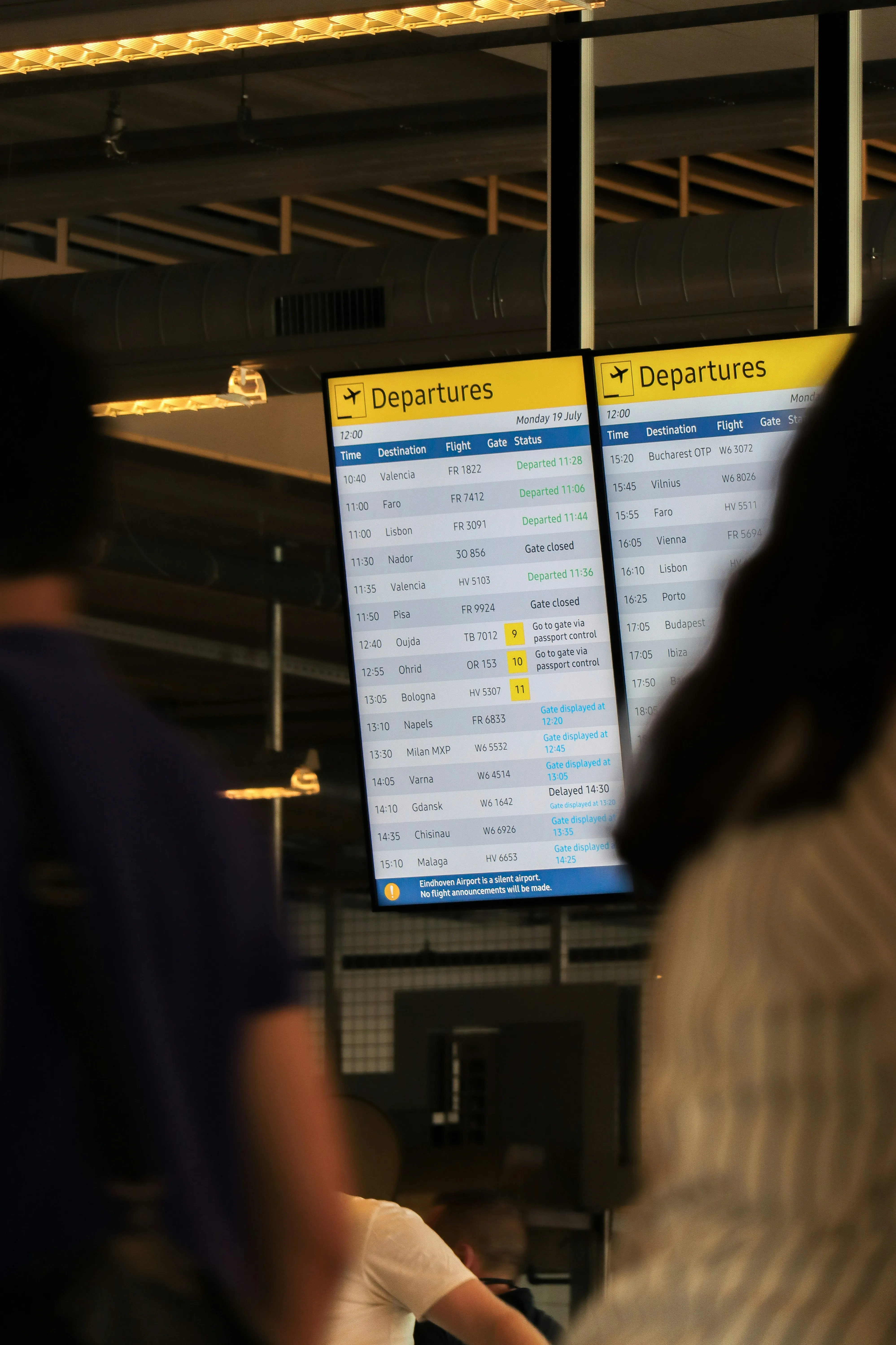 A traveller checking a departures board in an airport terminal